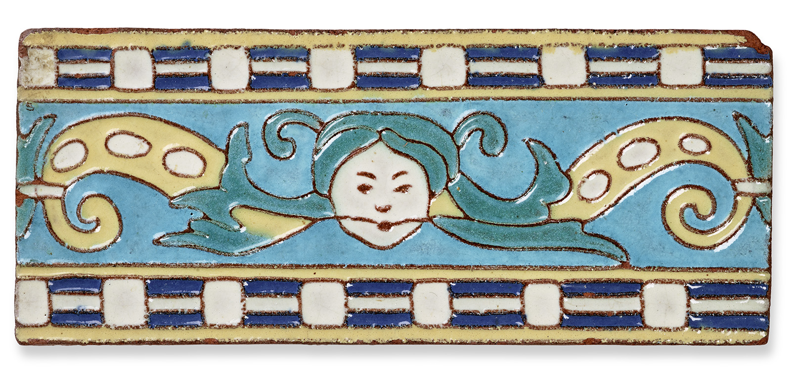 A rectangular ceramic tile features a stylized face with flowing blue hair at the center. The background is light blue, surrounded by a border of blue and beige rectangles and swirling yellow leaf-like designs.